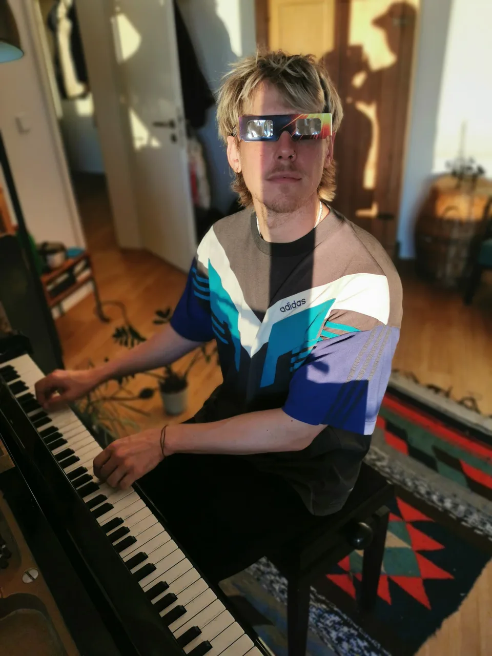 Musiker Astronaut mit Sonnenfinsternisbrille am Klavier